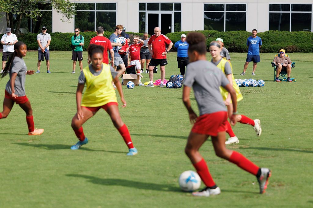 A group of young girls are playing soccer on a field