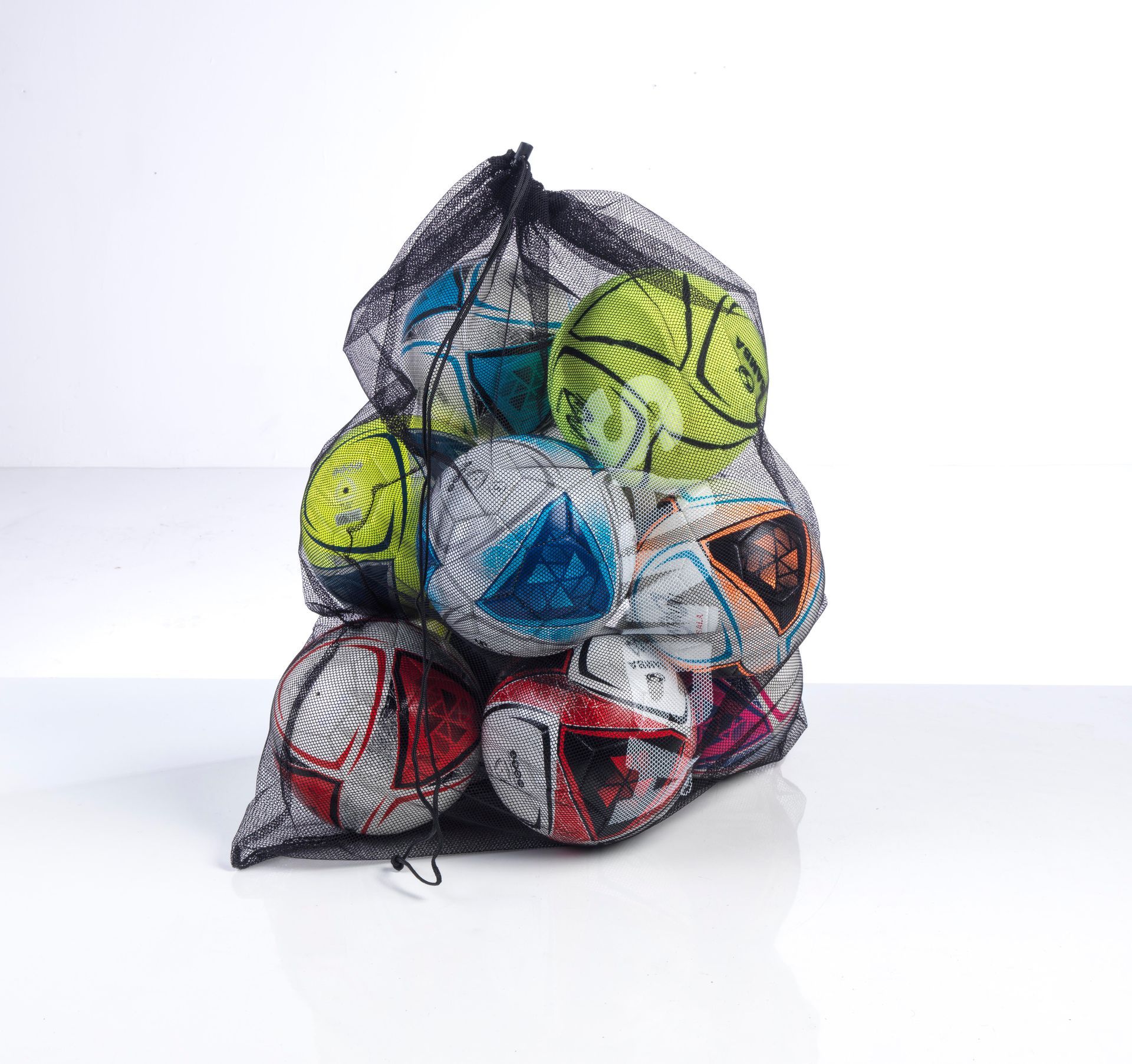 A mesh bag filled with soccer balls on a table