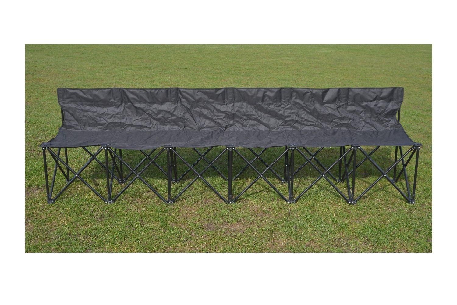 A black folding bench is sitting in the grass