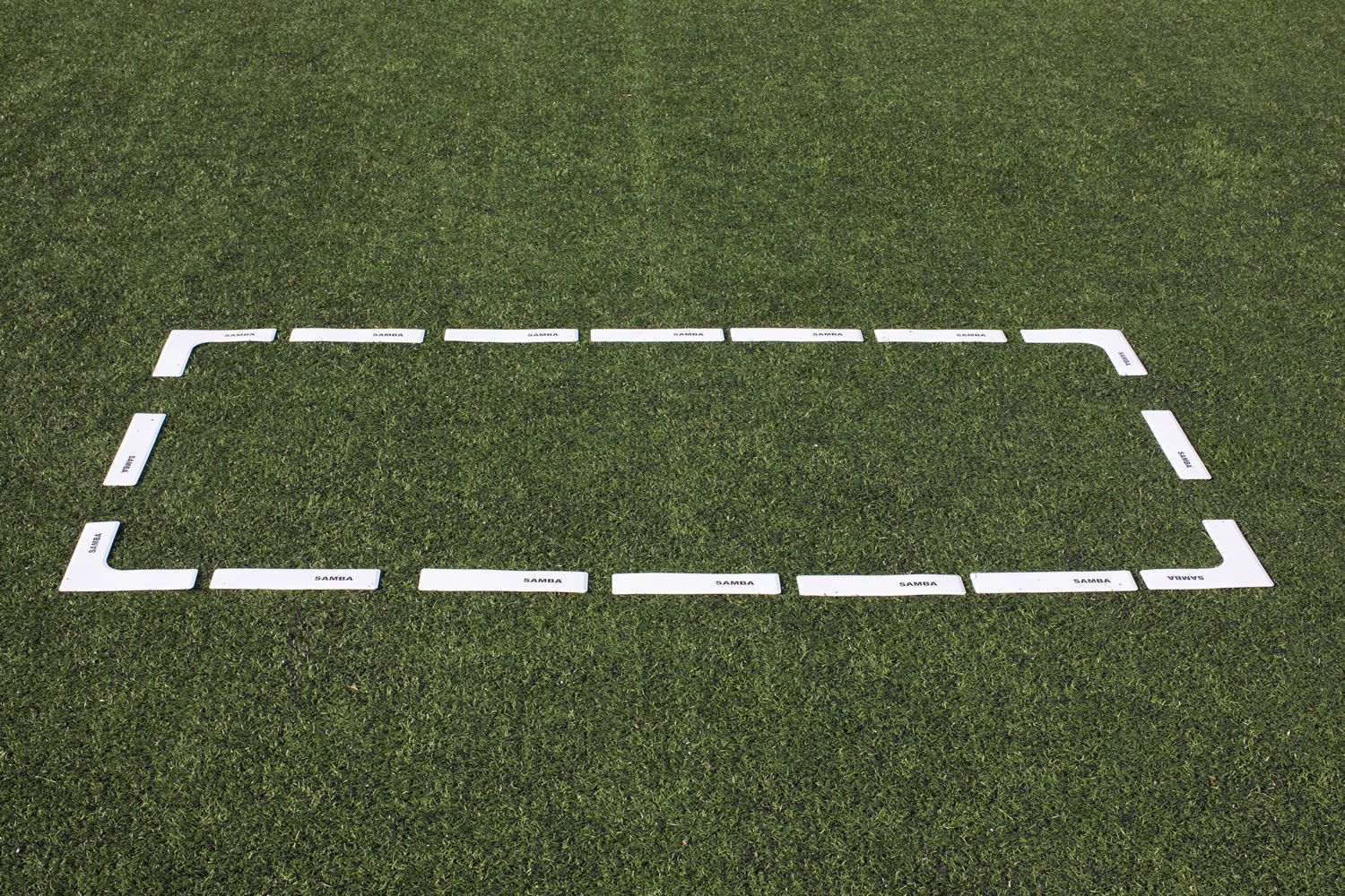 A white rectangle is painted on the grass on a soccer field.