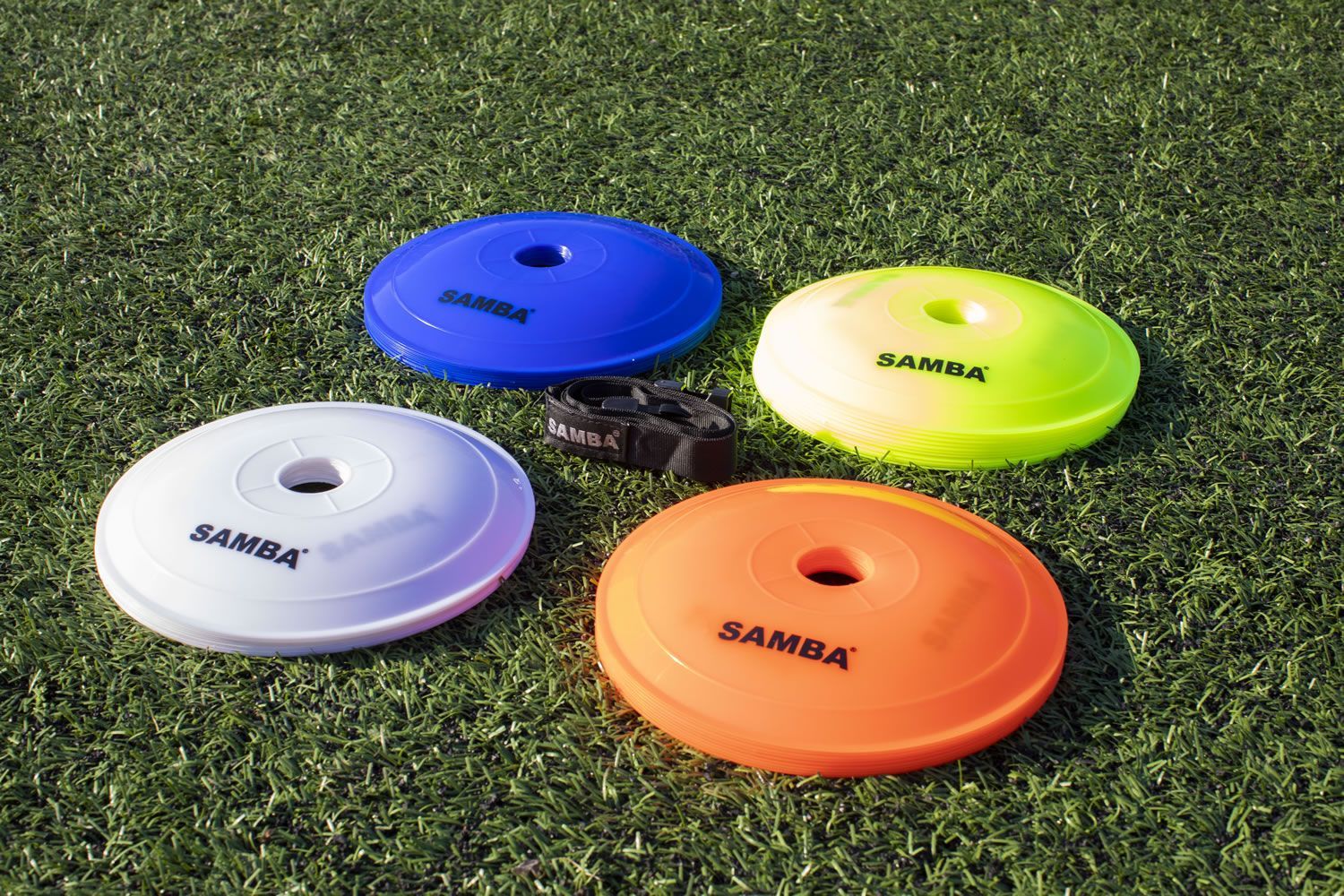 Four different colored samba discs are sitting on the grass