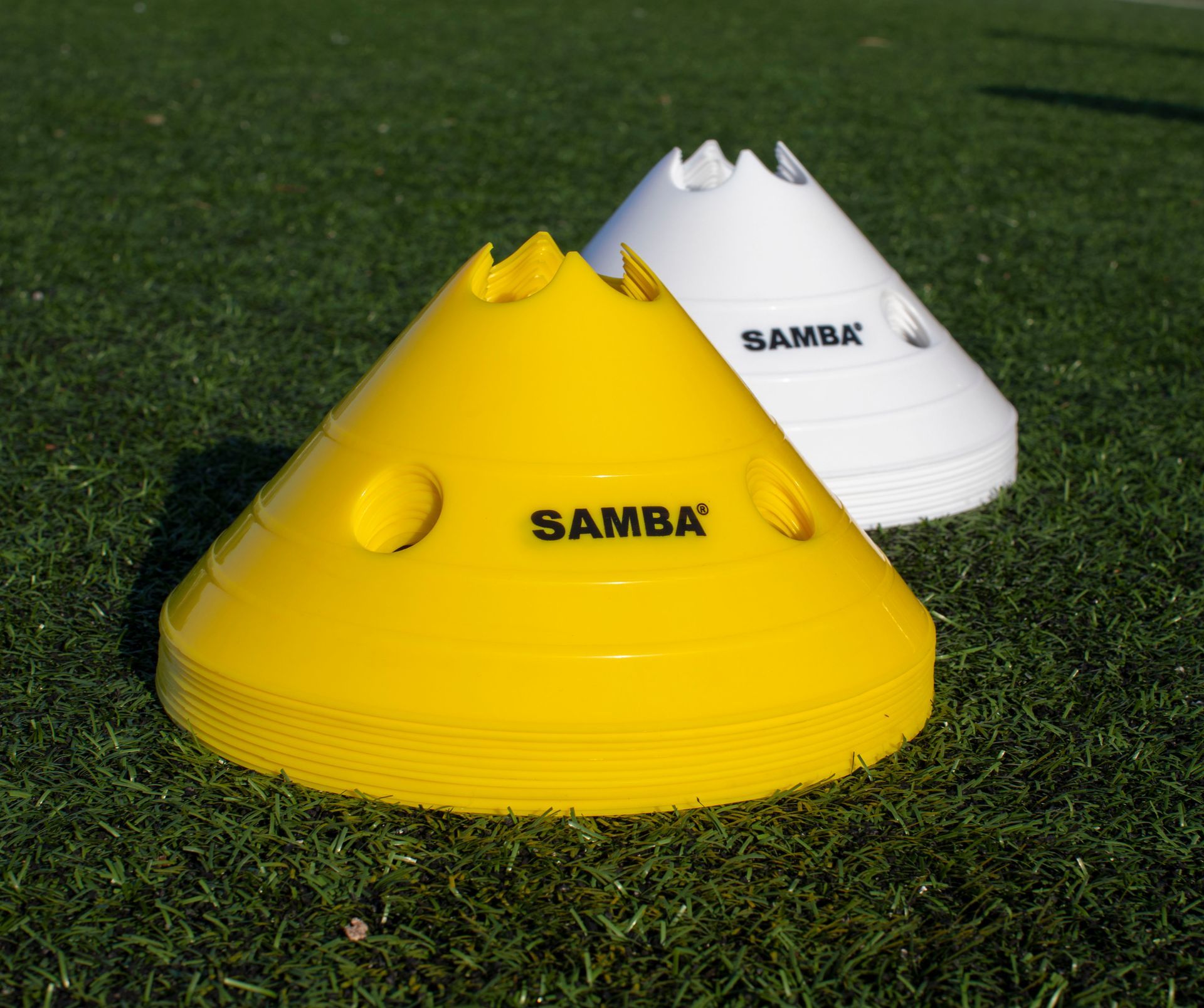 Three samba cones are sitting on a green field
