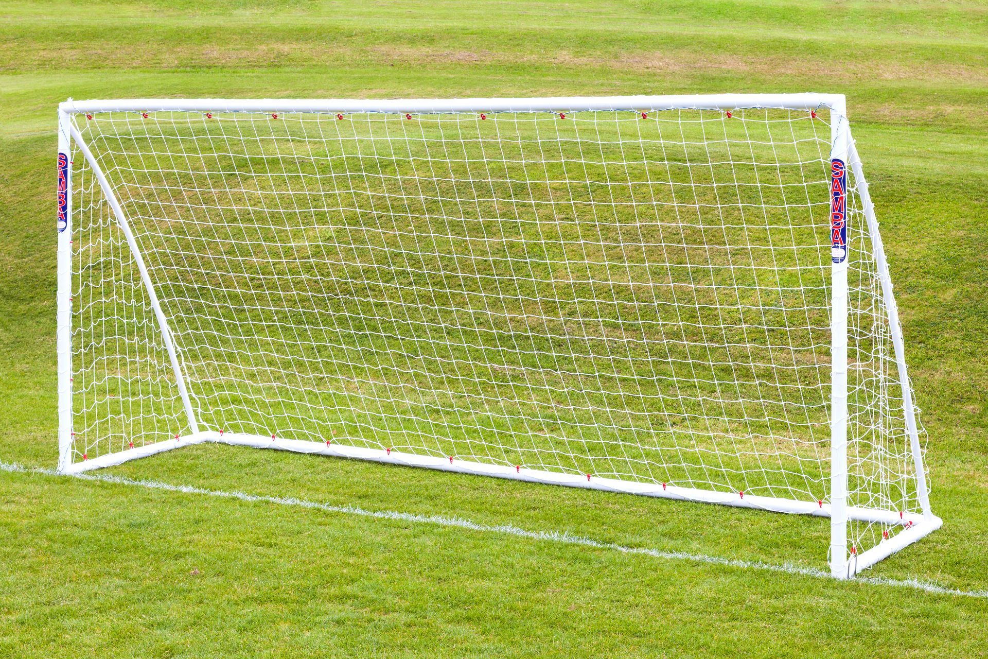 A white soccer goal on a lush green field