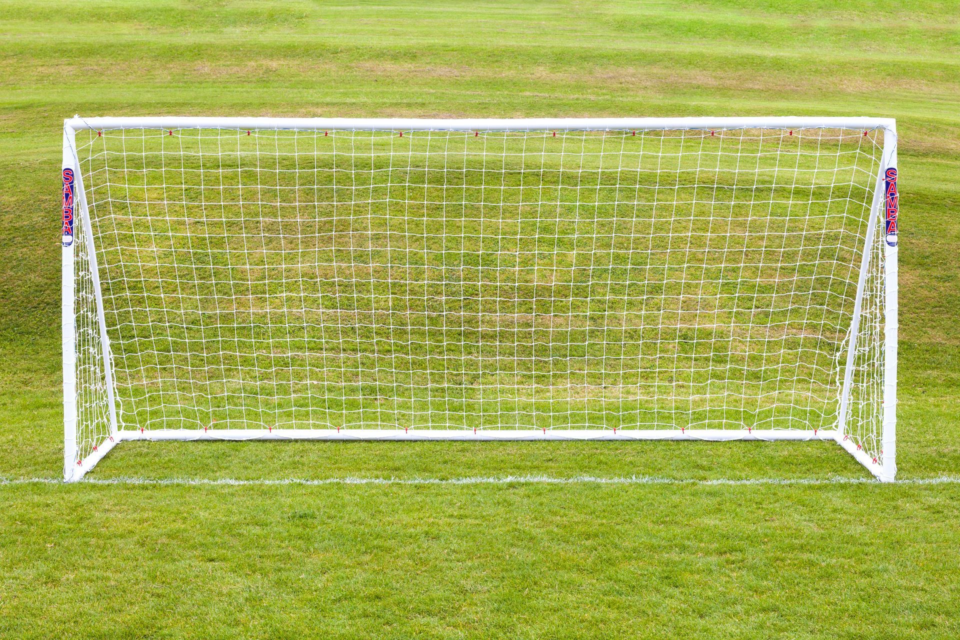 A white soccer goal on a lush green field