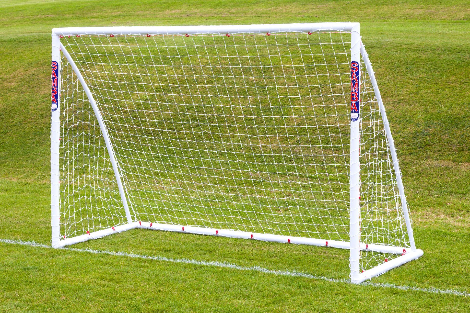 A white soccer goal with red white and blue stripes on it