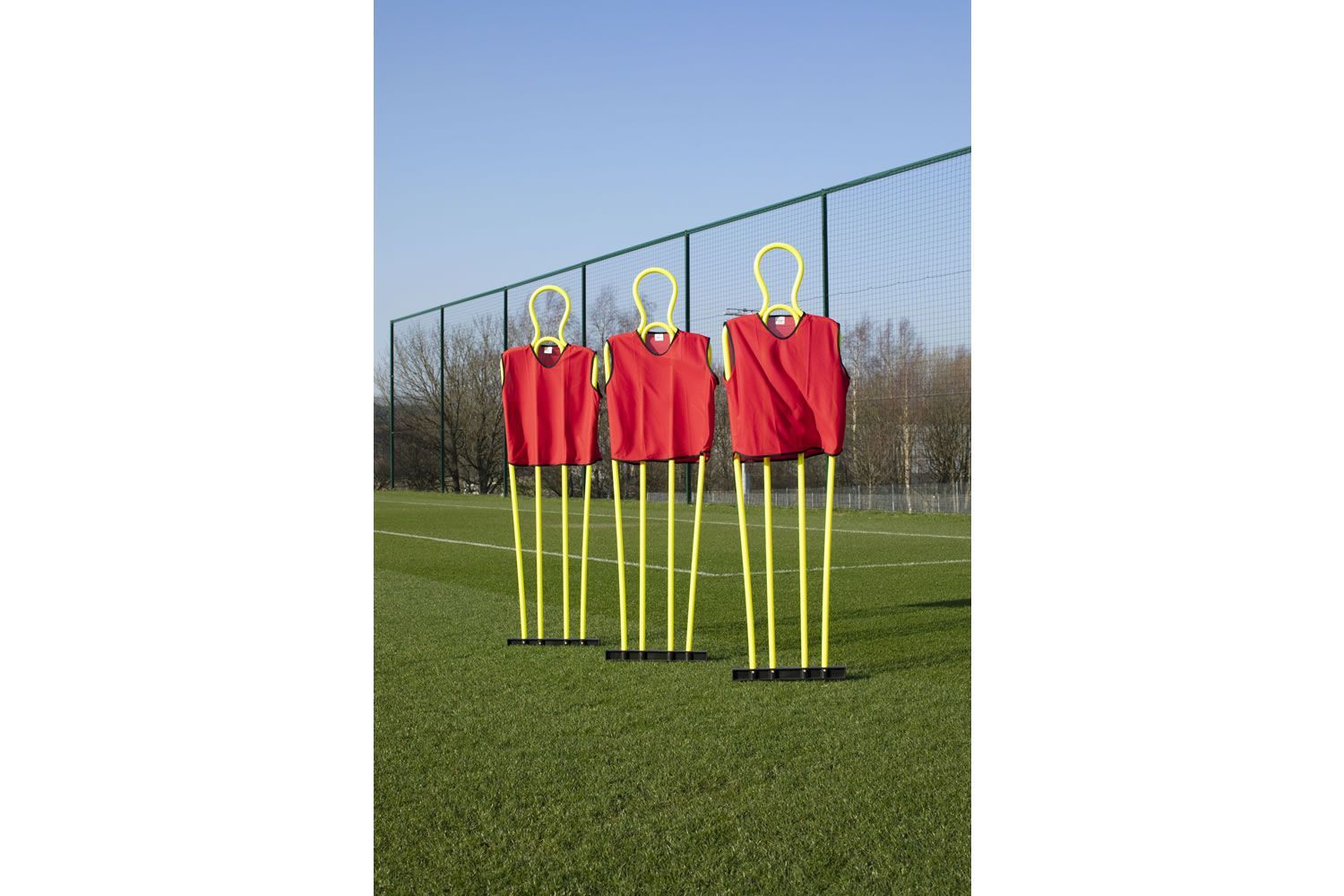 A row of yellow mannequins on a soccer field