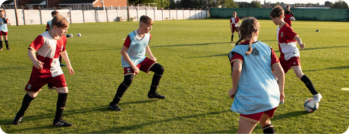 A group of children are playing soccer on a field