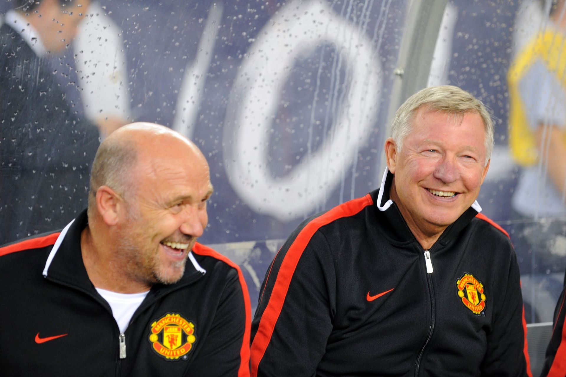 Two men wearing manchester united jackets are smiling