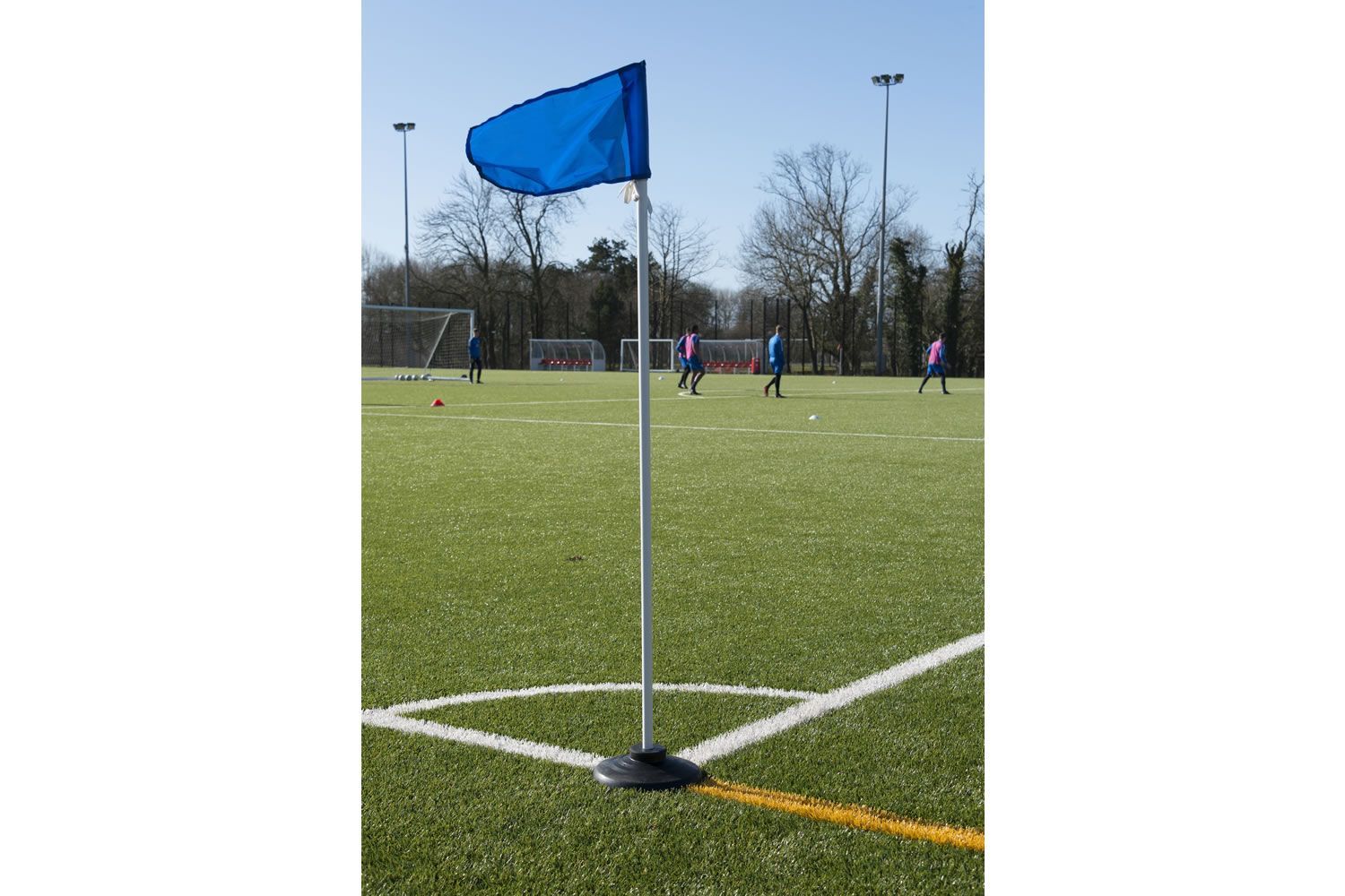 A soccer field with a blue flag in the corner