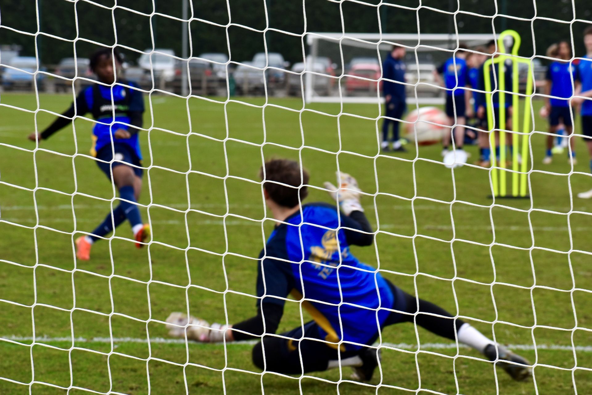 A soccer goalie in a blue jersey with the word united on it