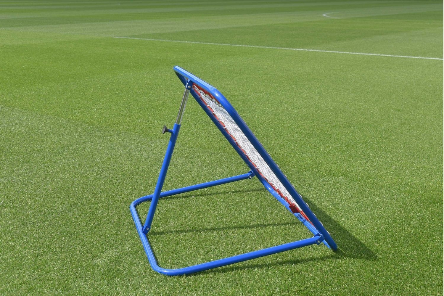 A soccer ball is going through a net on a field