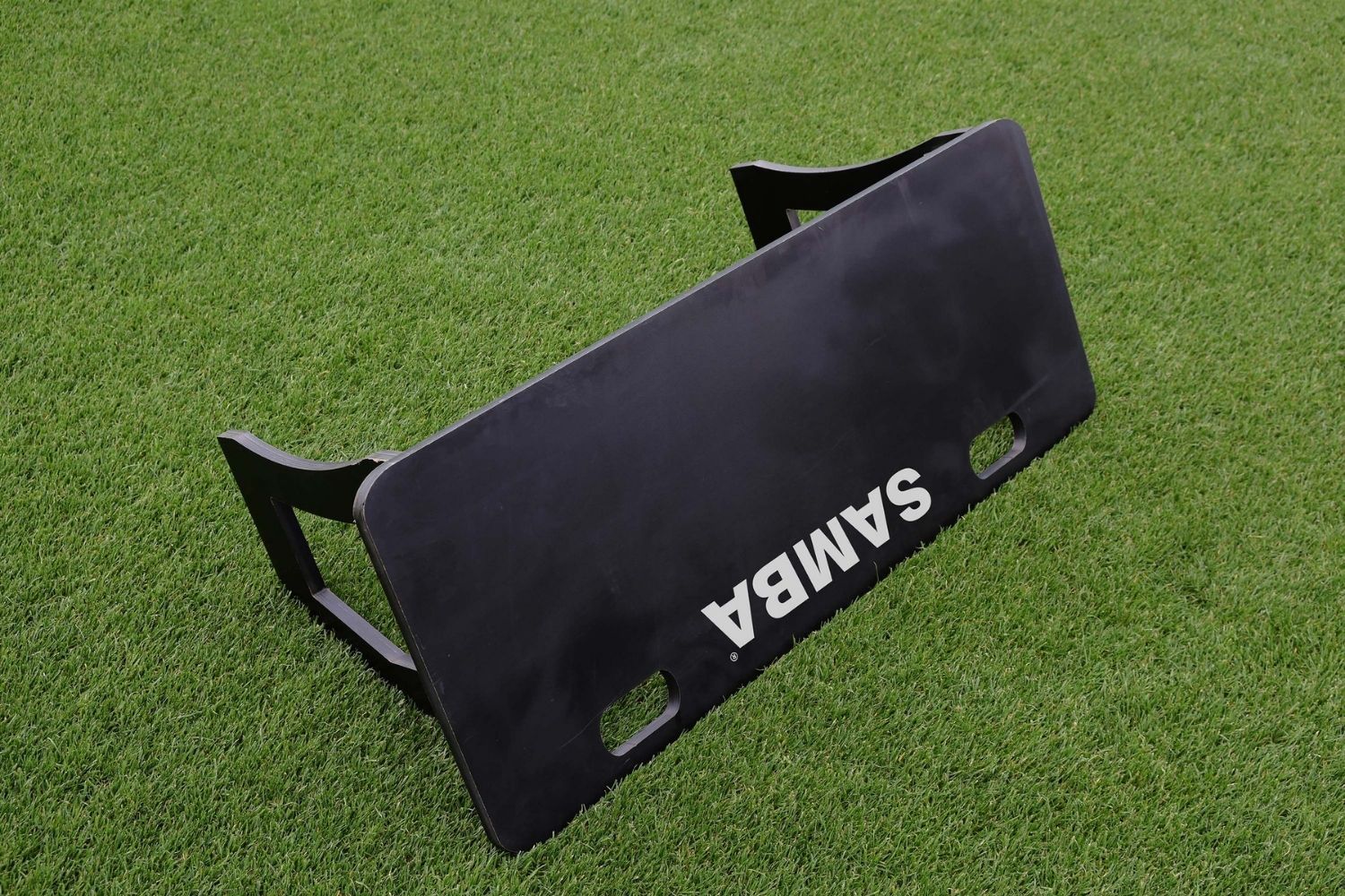 A soccer ball is sitting next to a samba board