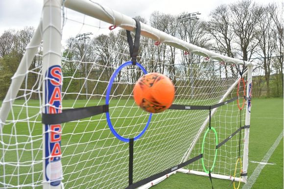 A soccer goal with a ball and hoops attached to it