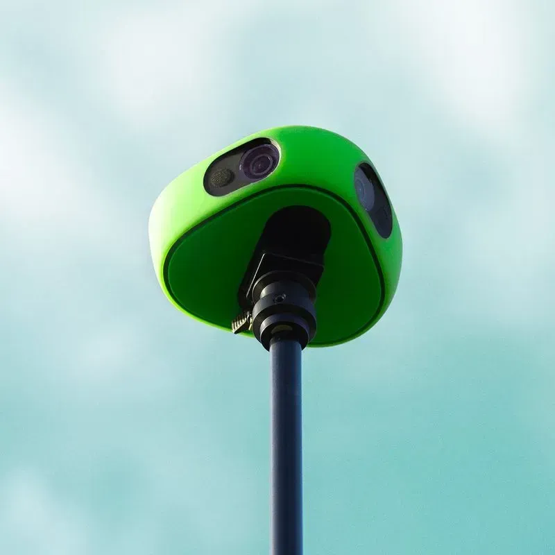 A green camera on a pole against a blue sky