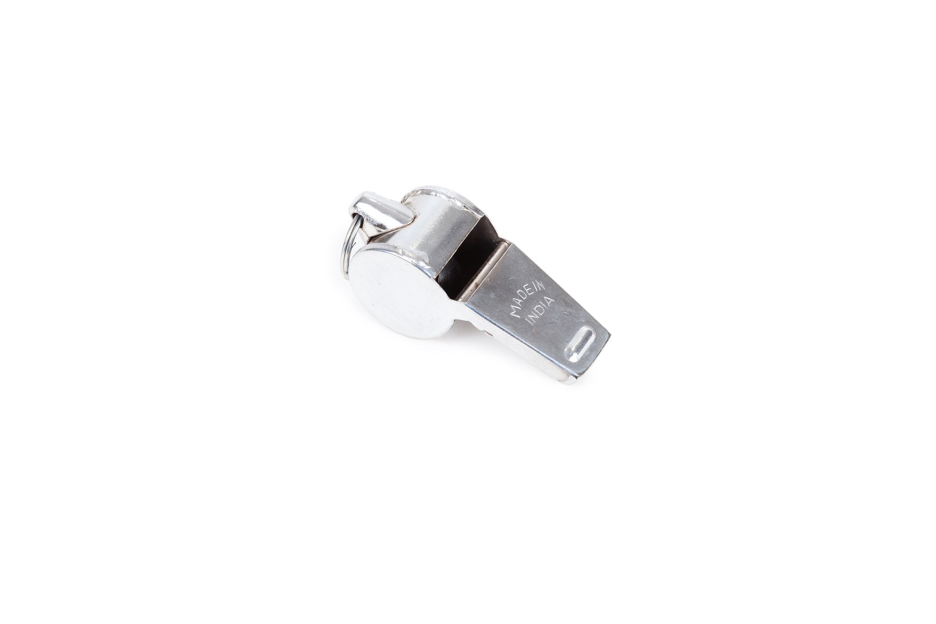 A silver whistle is sitting on a white surface.