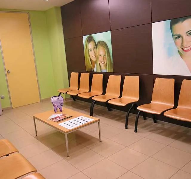 Una sala de espera con sillas y una mesa con un diente encima.