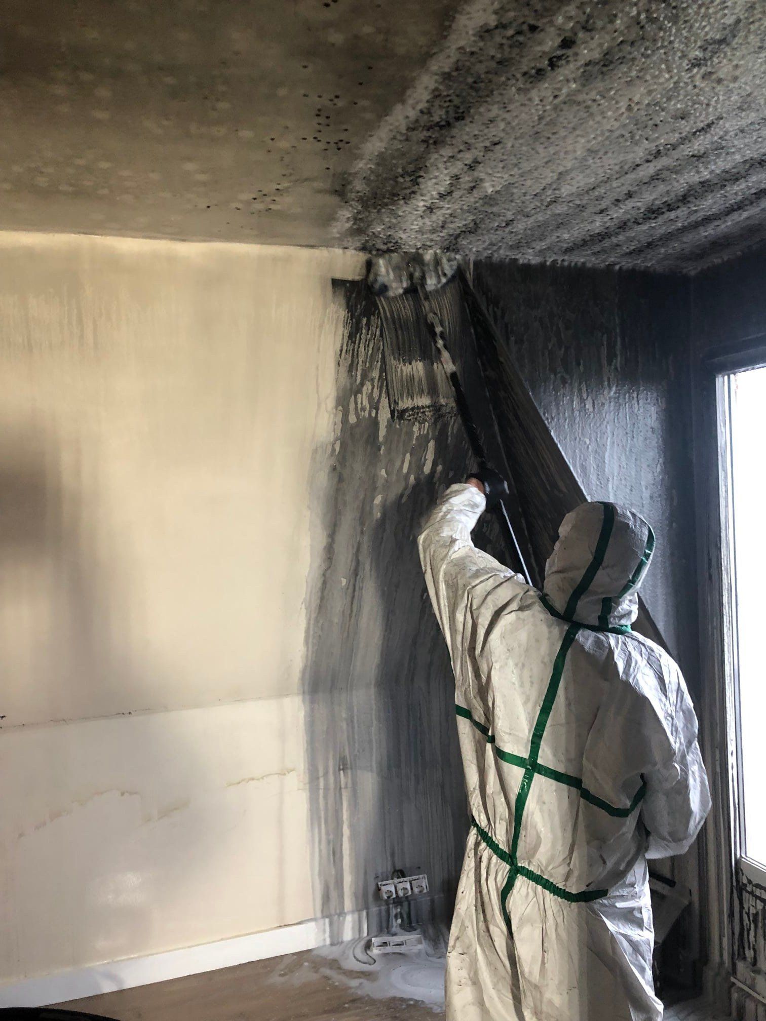 Agent de nettoyage de la SCEN intervenant pour nettoyer une pièce après un incendie