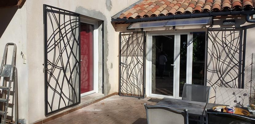 Patio avec des décorations en fer forgé noir ouvert sur des murs blancs