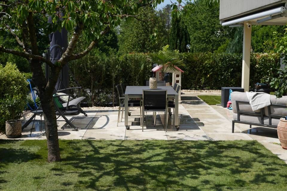 Moderne weisse Reihenhaussiedlung mit zickzackförmigen Dächern und einem grünen Innenhofgarten