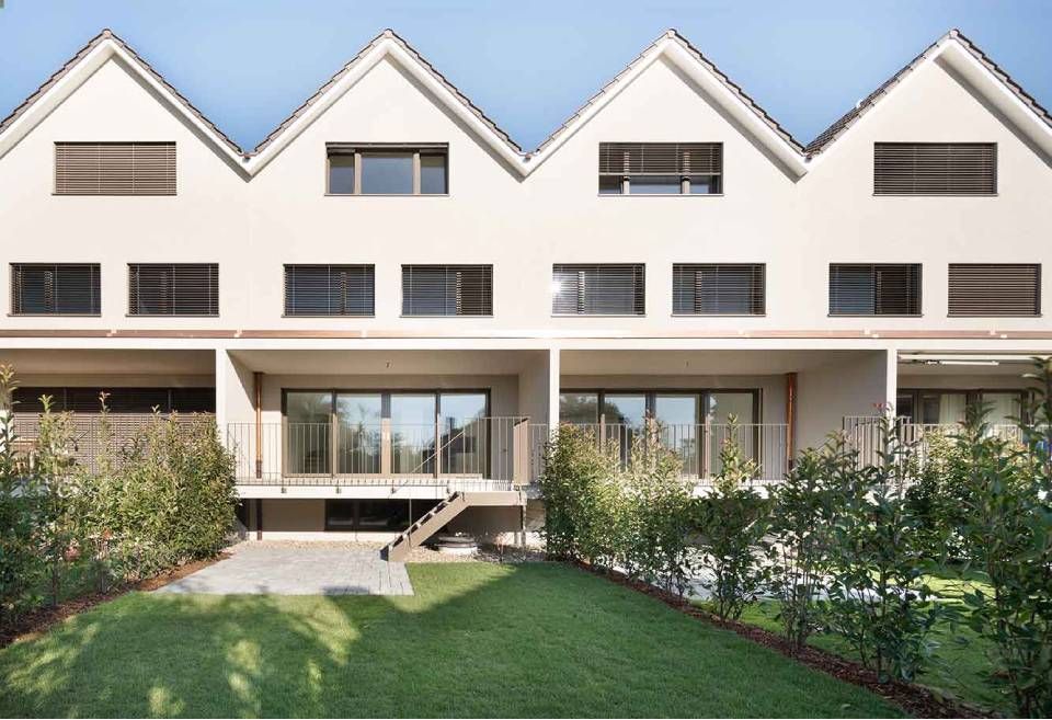 Moderner Hinterhof mit grünem Rasen, weissem Haus, Hecken und Poolrand