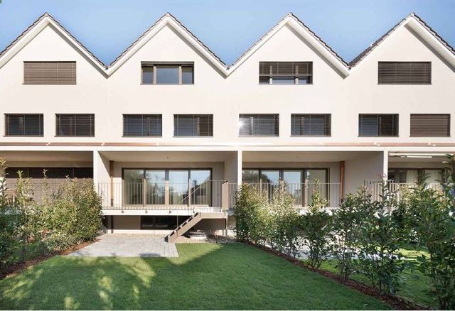 Moderner Hinterhof mit grünem Rasen, weissem Haus, Hecken und Poolrand