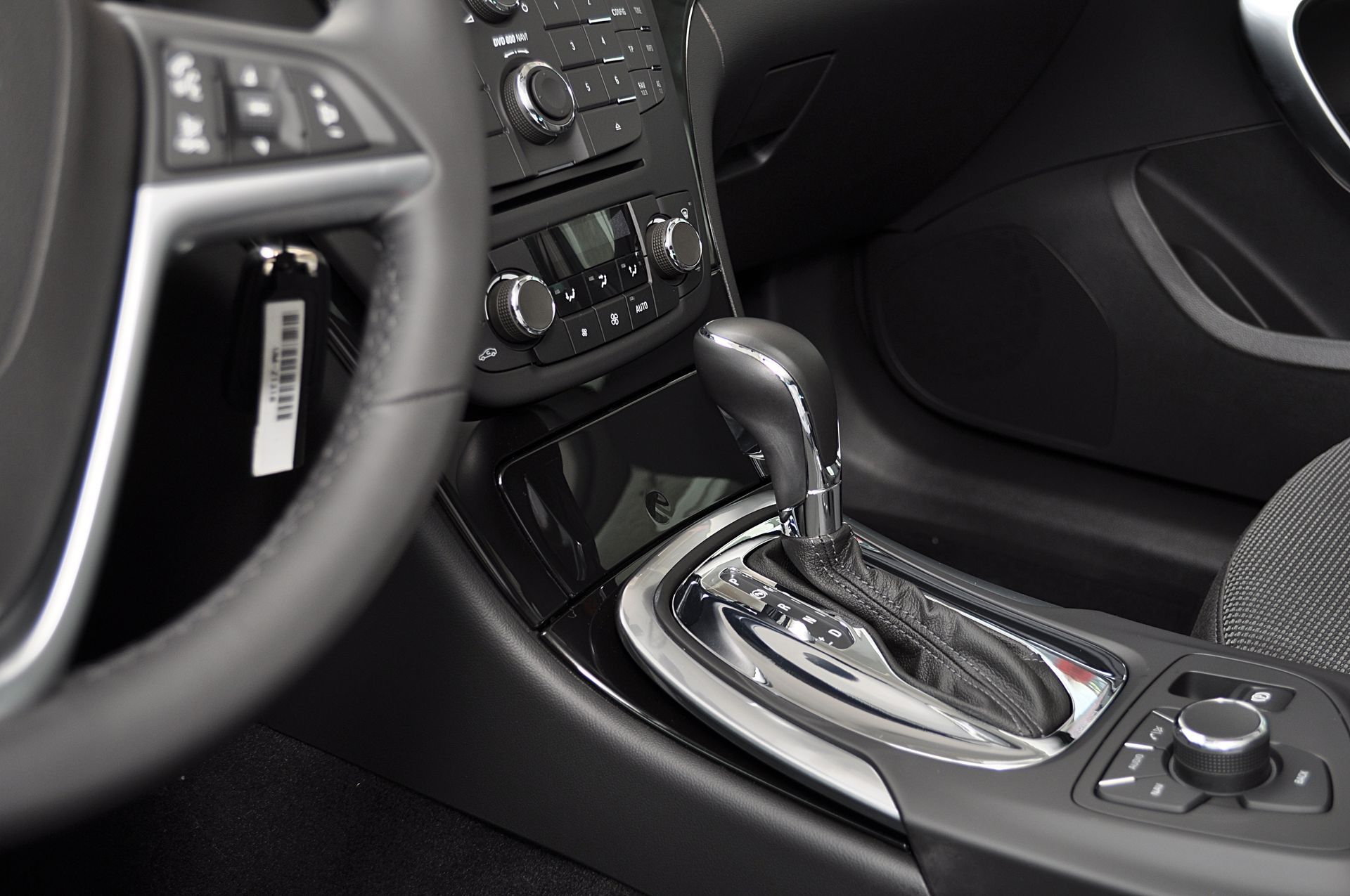 Intérieur de la voiture avec le volant, la console centrale, le sélecteur de vitesse et les commandes du tableau de bord.