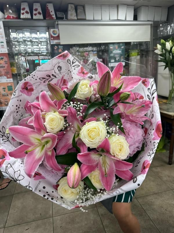 Composition florale avec des lys roses