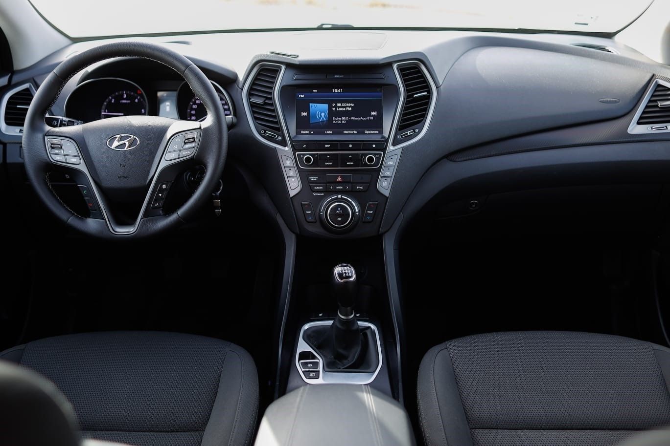 El interior de un coche con volante y radio.