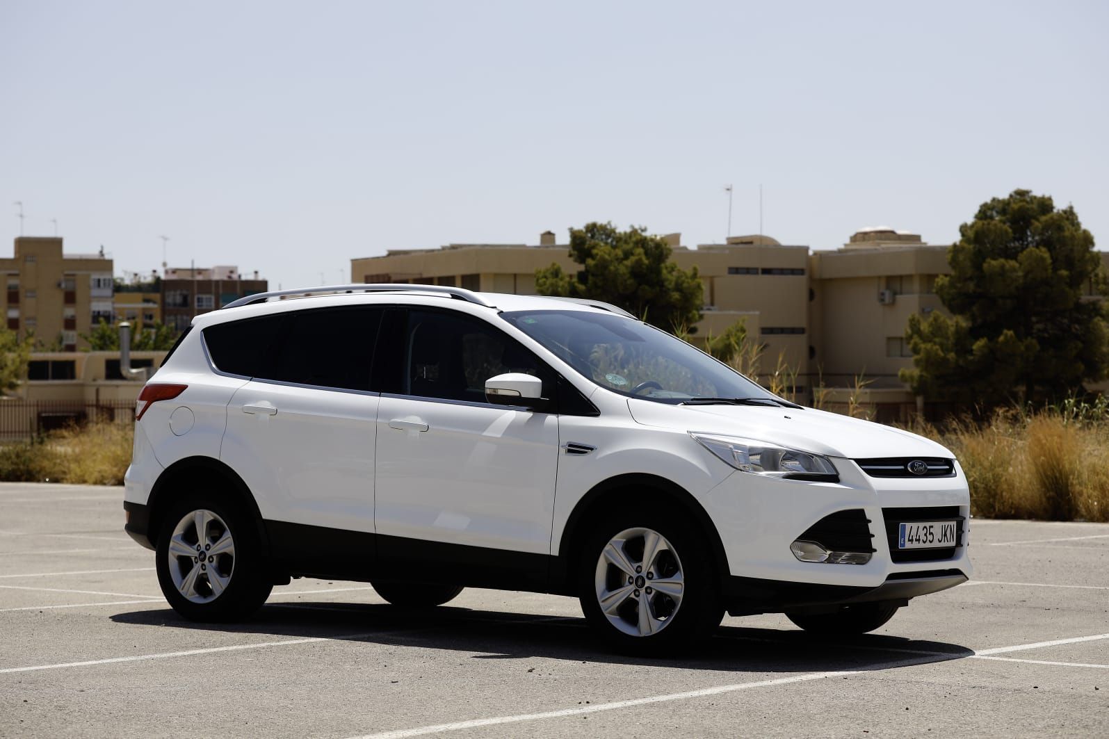 Una camioneta Ford blanca está estacionada en un estacionamiento