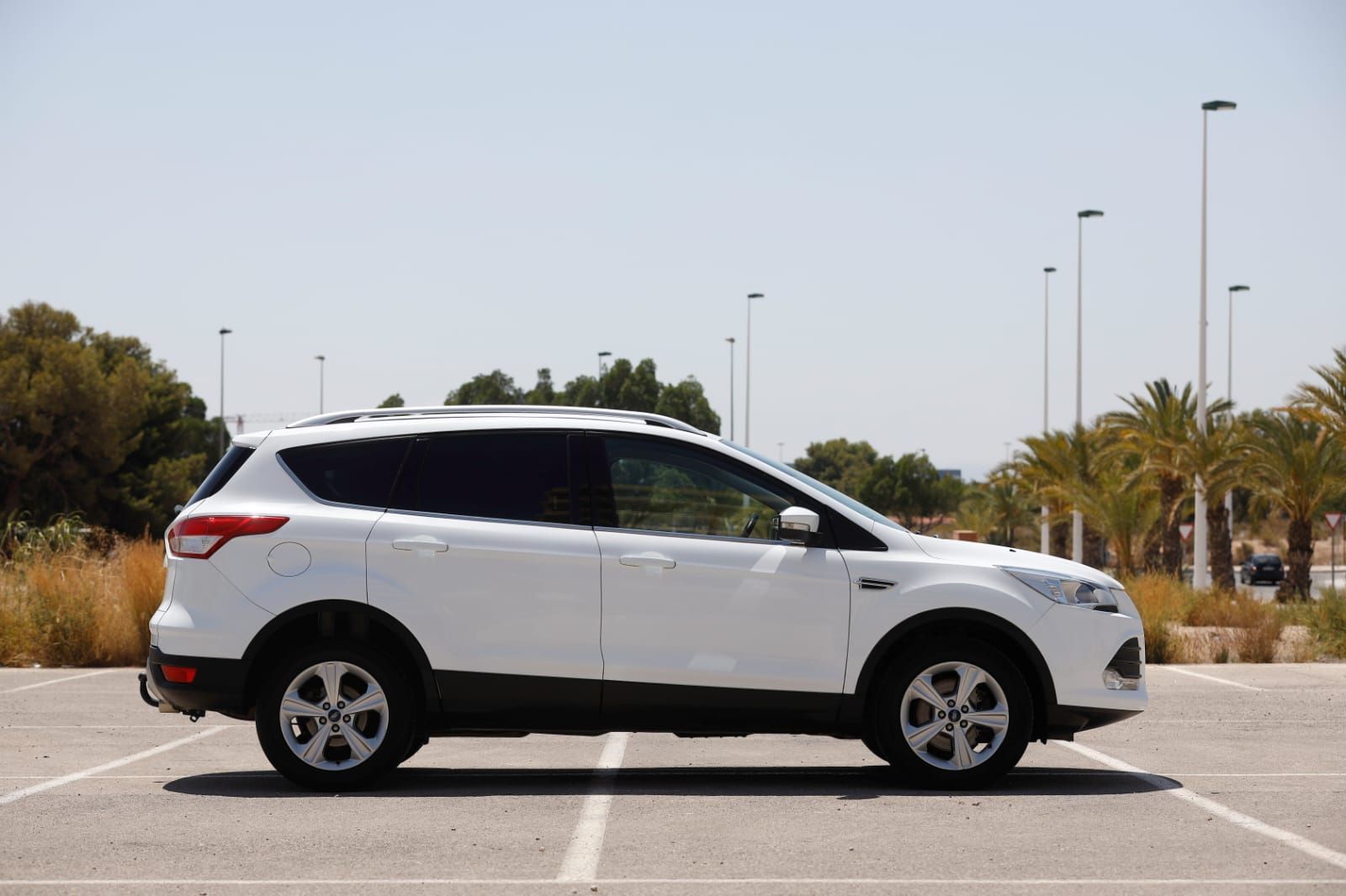 Un todoterreno blanco está estacionado en un estacionamiento.