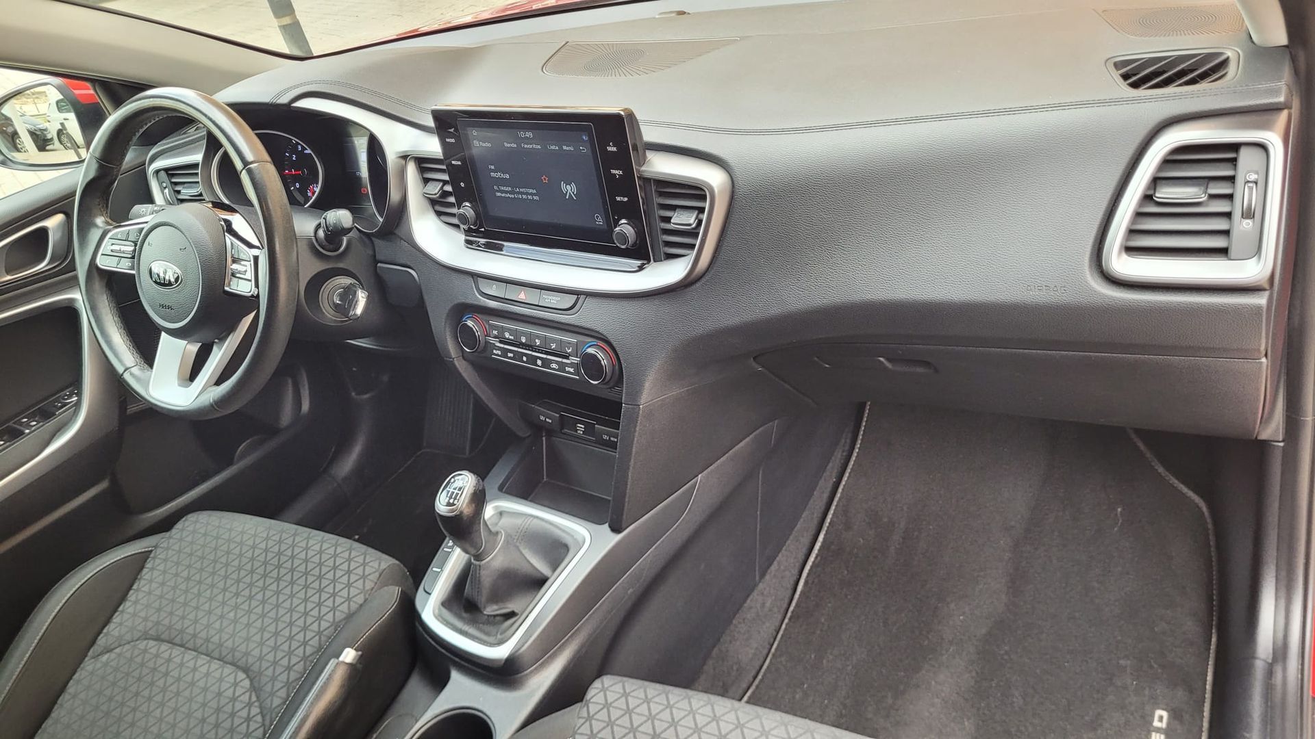El interior de un coche con tablero de instrumentos y volante.