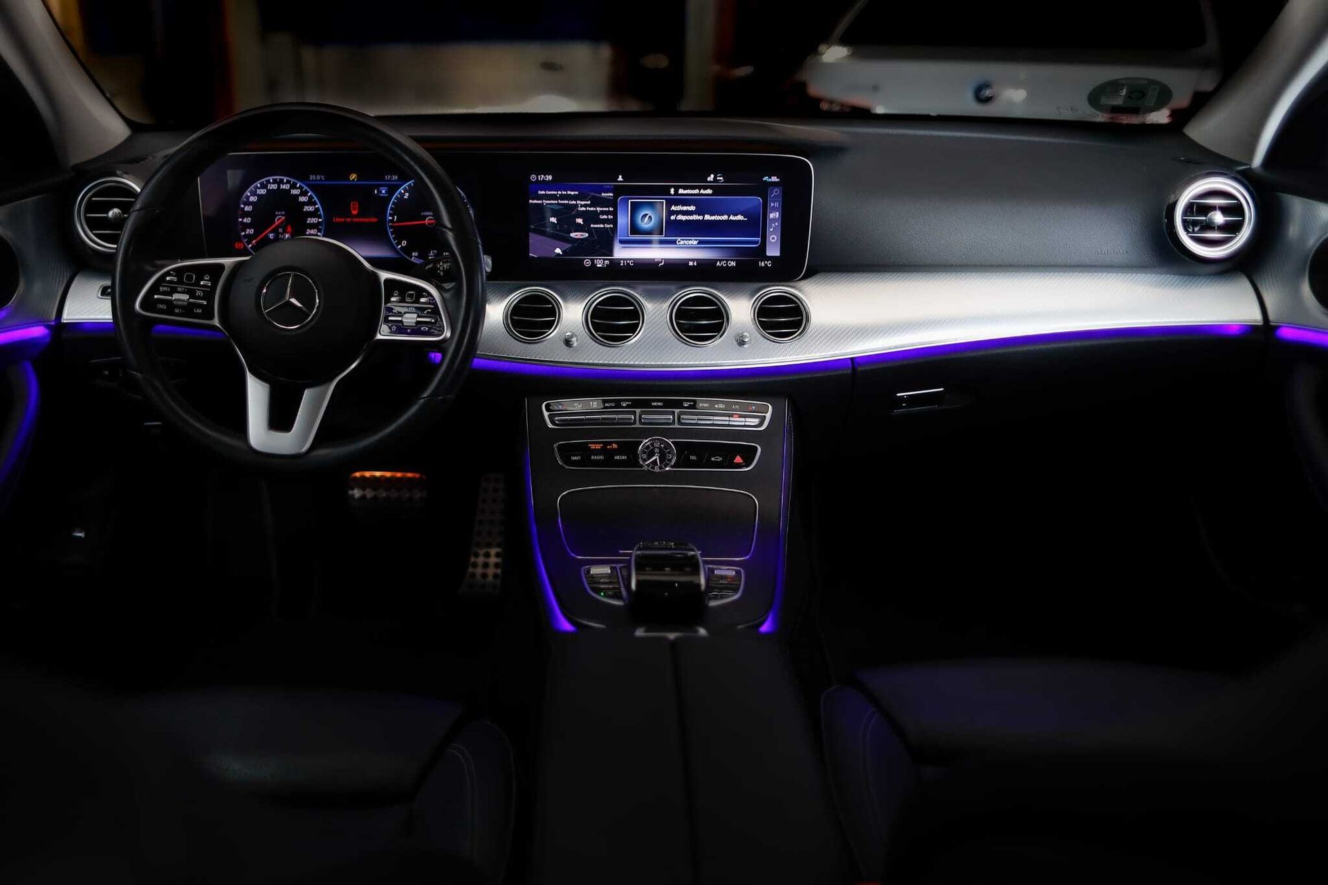 El interior de un Mercedes Benz Clase E con volante y tablero de instrumentos.