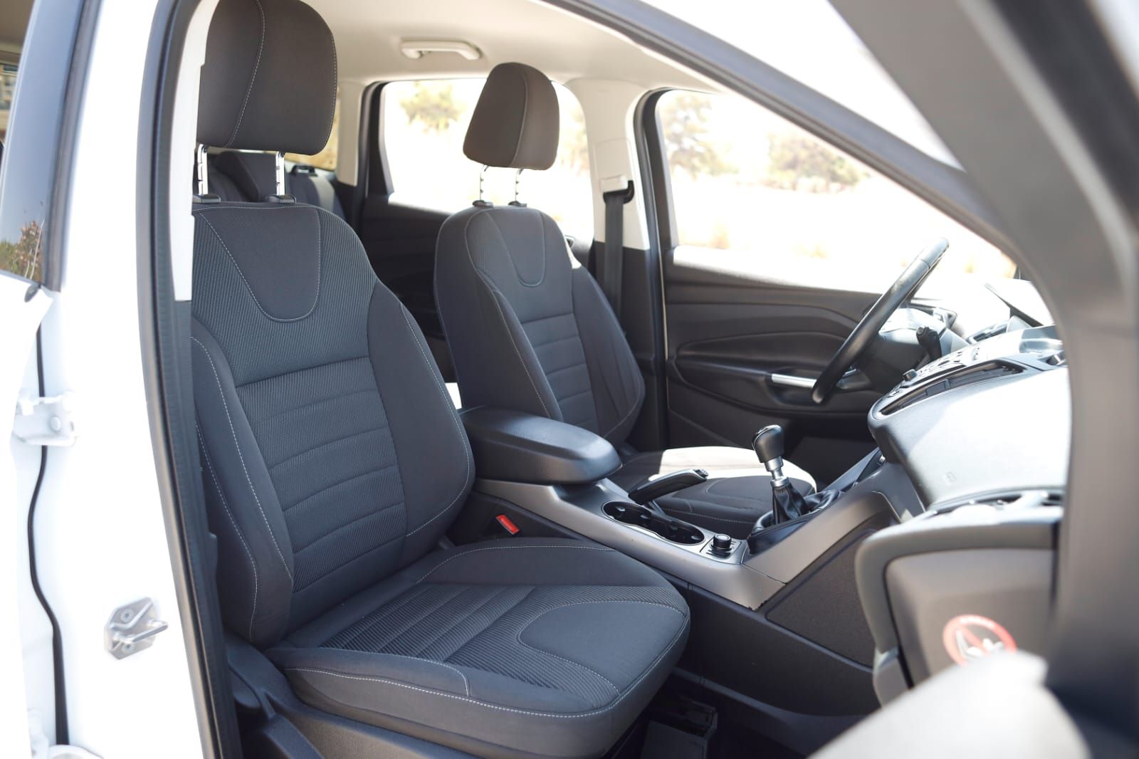 Un coche blanco con asientos negros y volante
