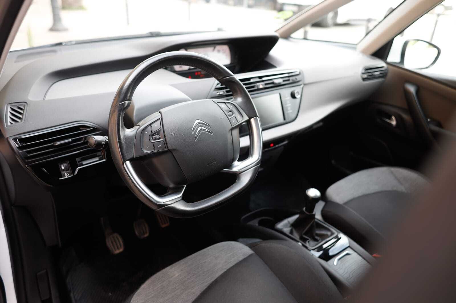 El interior de un coche con volante y asientos.