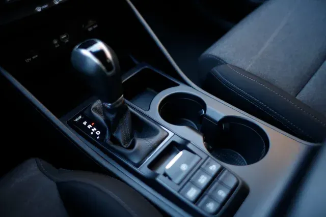 Un primer plano de la palanca de cambios y el portavasos de un automóvil.