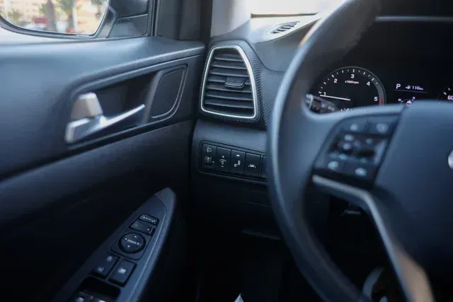 Un primer plano del volante y la manija de la puerta de un automóvil.