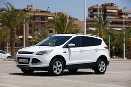 Un Ford Escape blanco está estacionado en un estacionamiento.