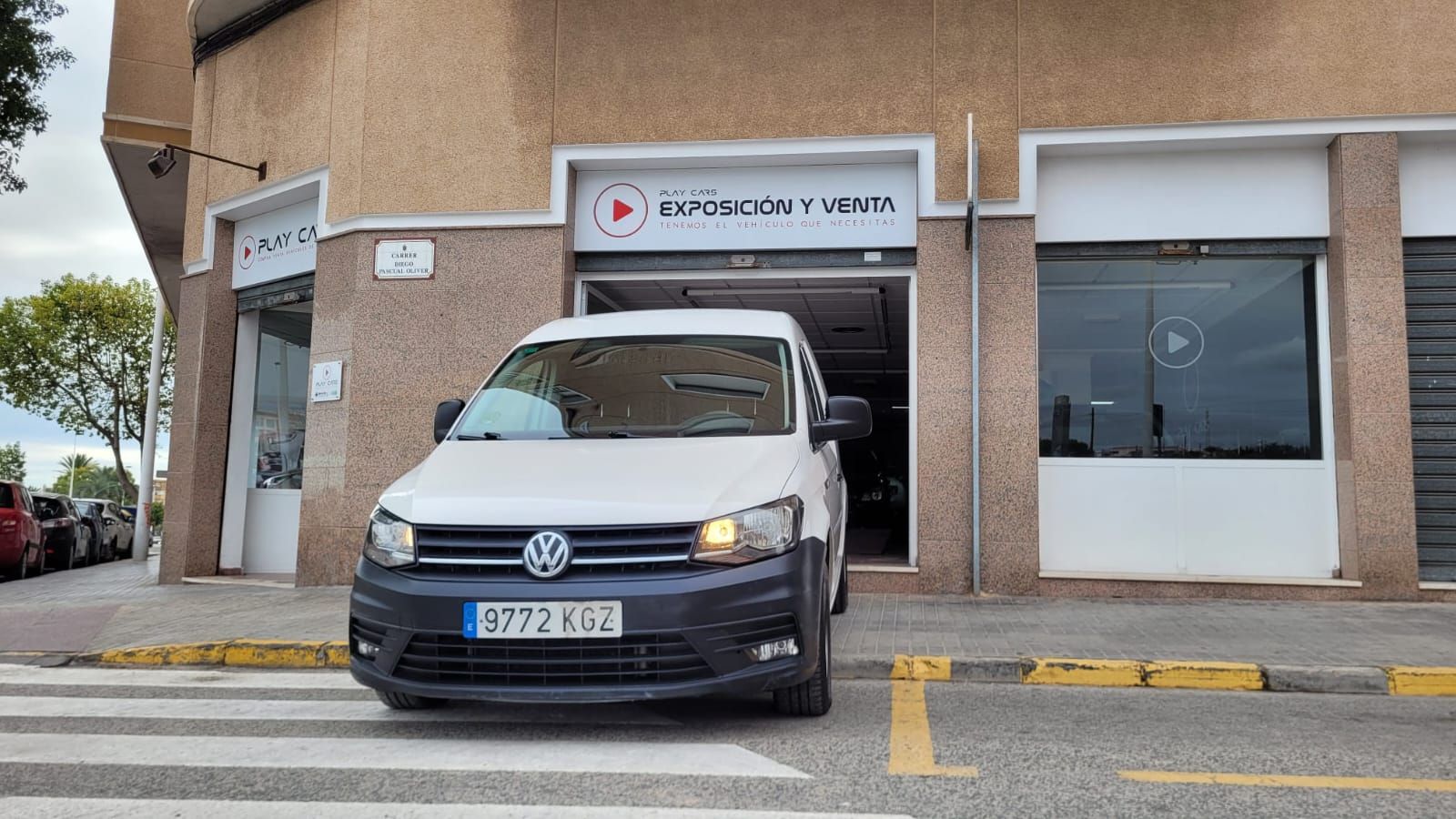 Una camioneta blanca está estacionada frente a un edificio.