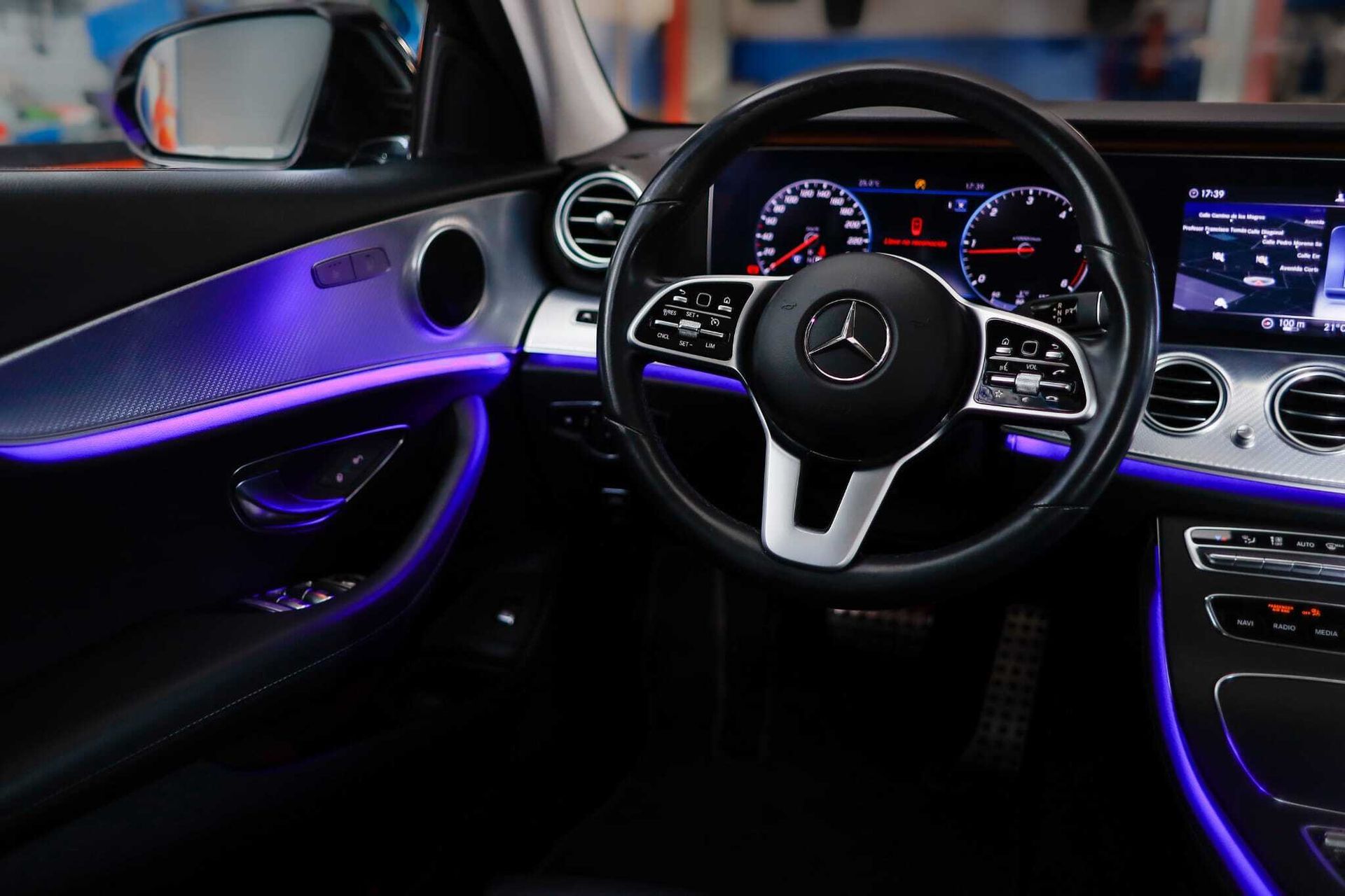 El interior de un automóvil Mercedes Benz con volante y tablero de instrumentos.