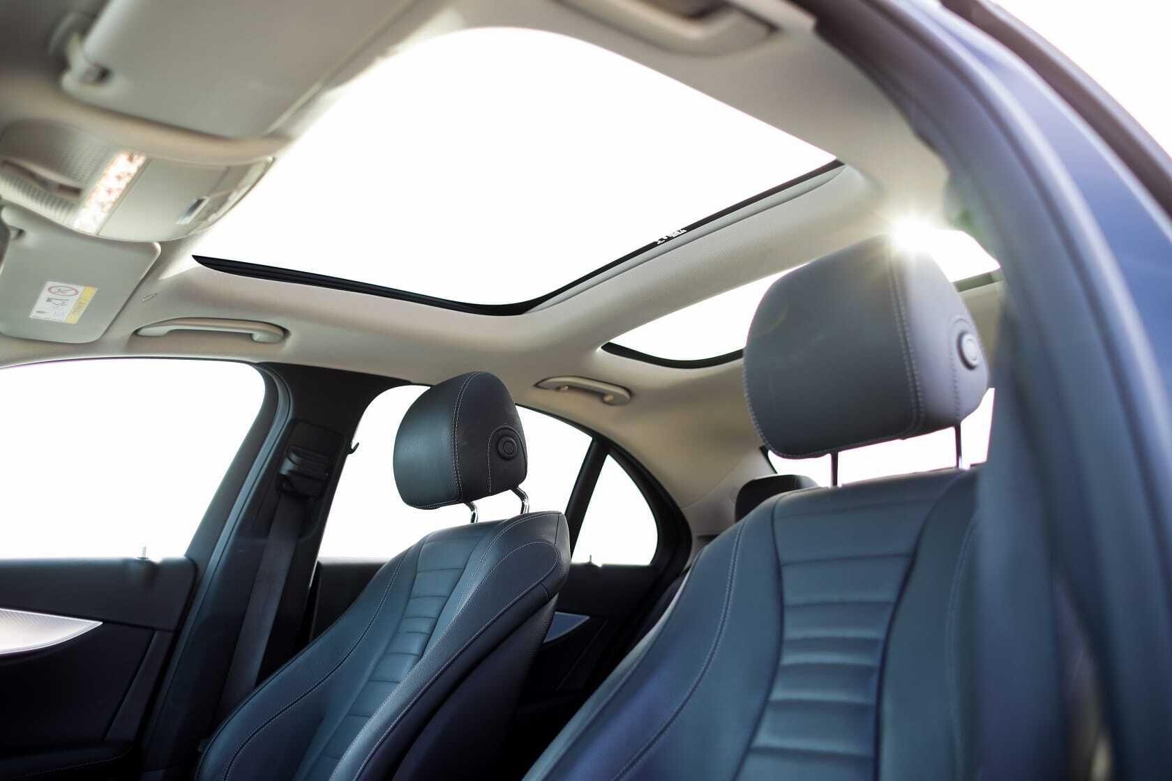 Un coche azul con techo corredizo y reposacabezas