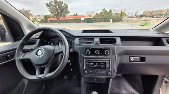El interior de un coche con volante y tablero.