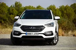Un Hyundai Santa Fe blanco está estacionado en un camino de grava.