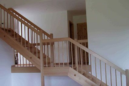 Eine Holztreppe mit einem Holzgeländer in einem Haus