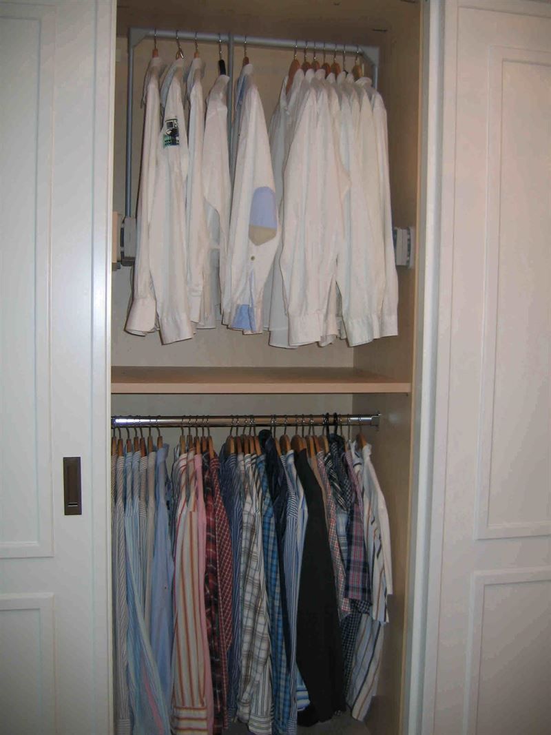 Ein Schrank voller Kleidung, darunter Hemden und Röcke