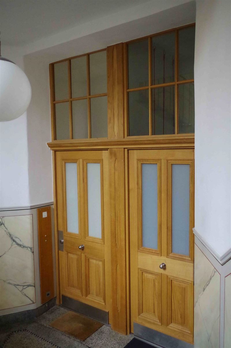 Eine Holztür mit vielen Fenstern in einem Flur.
