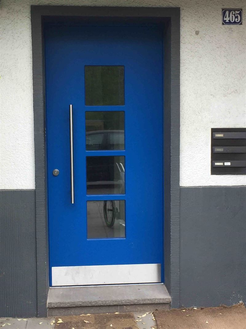 Eine blaue Tür befindet sich an der Seite eines Gebäudes