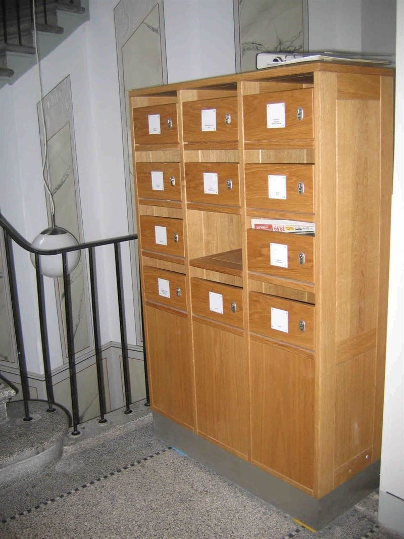 Ein Holzschrank mit vielen Schubladen in einem Flur