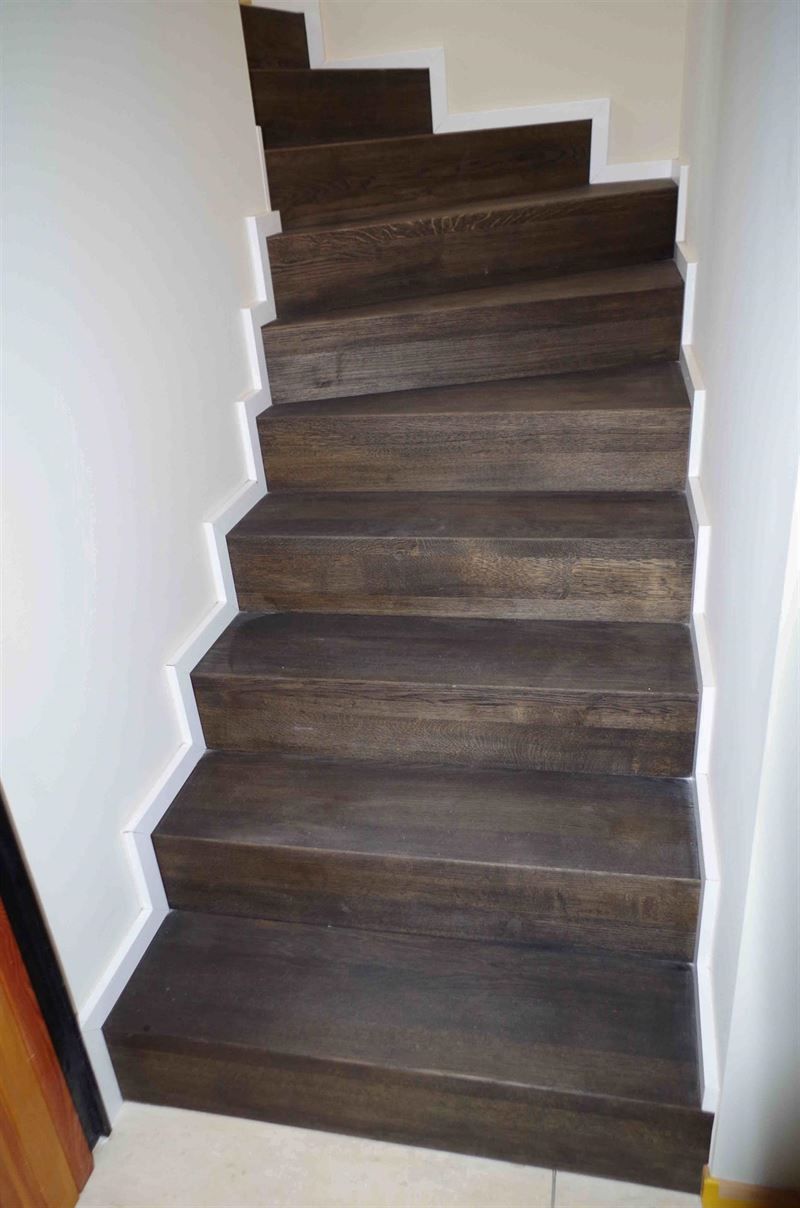 Eine Holztreppe führt in den zweiten Stock eines Hauses.