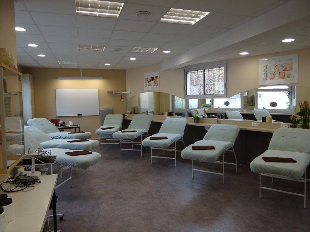 Salle de spa avec tables de massage et miroirs.
