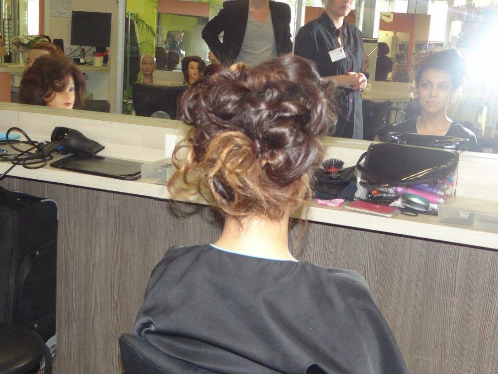 Personne arborant une coiffure sophistiquée en salon de coiffure.